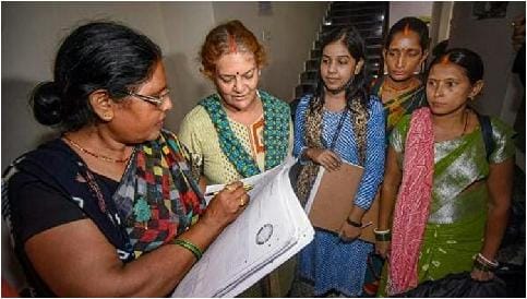 Enumerator recording caste information of a rural household during a census exercise